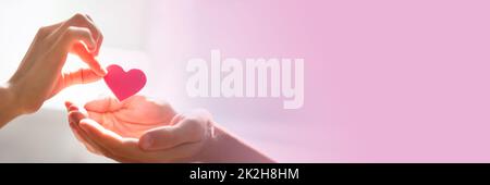 Frau mit Herz auf der Hand Stockfoto