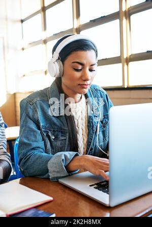 Scheut einen fleißigen Schüler. Eine kleine Aufnahme einer attraktiven jungen Universitätsstudentin, die im Unterricht an ihrem Laptop arbeitet. Stockfoto