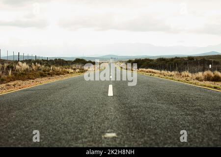 Die offene Straße. Aufnahme einer langen, offenen Straße, die sich weit in die Ferne erstreckt. Stockfoto