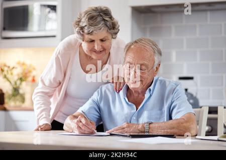 Sie waren so scharf wie wir verliebt waren. Aufnahme eines älteren Paares, das zu Hause über die Formalitäten ging. Stockfoto