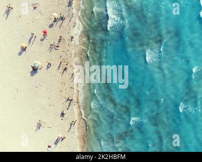 Izmir, Türkei - 17. August 2022: Luftaufnahme des Strandes von Ilica im Sommer Cesme Izmir Türkei sind Leute mit Sonnenschirmen am Strand Stockfoto