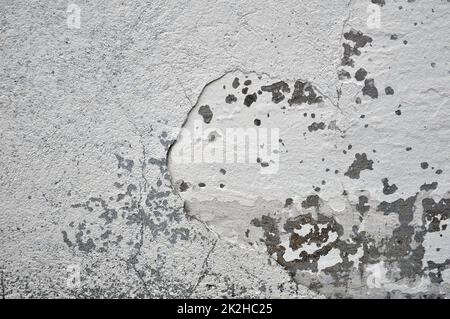 Leere alte verputzte Wandstruktur. Lackierte problematische Wandoberfläche. Verfallene Gebäudefassade mit beschädigtem Putz. Stockfoto