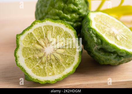 Frische Bergamotte Früchte mit in zwei Hälften geschnitten auf Holz Hintergrund. Stockfoto