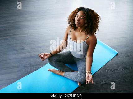 Meditation ist der Schlüssel zu großer Gesundheit. Aufnahme einer jungen Frau, die Yoga praktiziert. Stockfoto