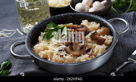 Pilzrisotto mit Petersilie und Parmesan garniert. Stockfoto