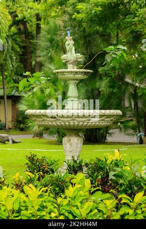 Der alte weiße Brunnen im Park ist ein beliebtes Gerät zur Gartendekoration Stockfoto