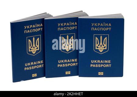 Drei auf weißem Hintergrund isolierte Reisepässe für ukrainische Staatsbürger oder Migranten zur visumfreien Einreise in die Europäische Union. Beschneidungspfad. Flüchtlinge in der Ukraine stehen in Konflikt mit Russland. Stockfoto