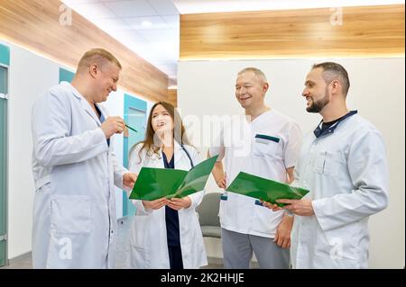 Gruppe von Ärzten, die im Krankenhausflur sprechen Stockfoto