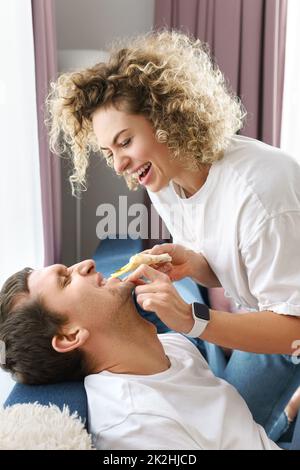 Glückliches Paar, das zu Hause leckere Pizza isst Stockfoto