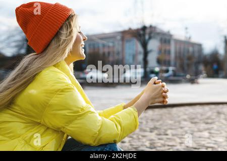 Stilvolle Mädchen tragen gelben Puffer und orange Strickmütze Stockfoto