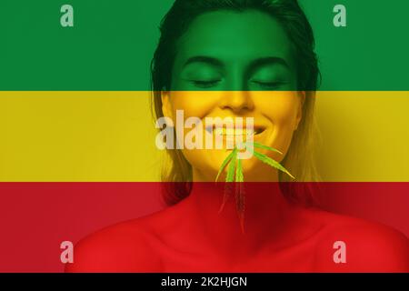 Portrait schöne Frau mit einem Cannabisblatt in den Farben der rastafarischen Flagge Stockfoto