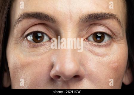 Müde Augen einer Frau mittleren Alters Stockfoto