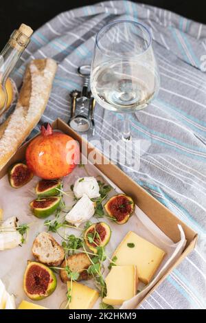 Verschiedene köstliche Speisen und ein Glas Wein beim Picknick. Stockfoto