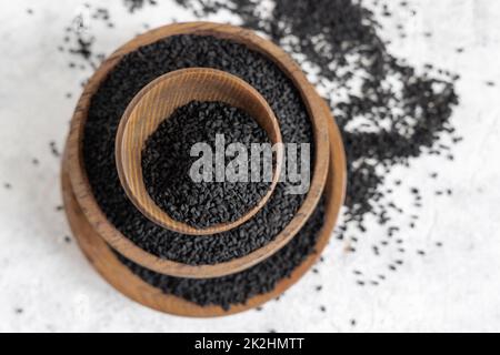 Indisches Gewürz Schwarzer Kreuzkümmel (Nigella sativa oder Kalonji) in Holzschüsseln, Draufsicht Stockfoto