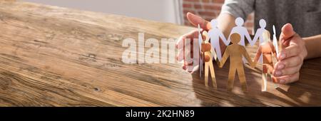 Die Hände Der Mitarbeiter Schützen Die Mitarbeiter Von Cutout Paper. Gleichberechtigtes Menschliches Konzept Stockfoto