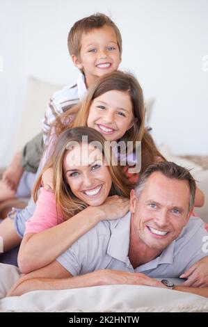 Bei der Familie geht es um Ausgewogenheit. Porträt einer glücklichen, jungen Familie von vier Kindern, die übereinander stapelt ist. Stockfoto