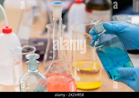 Verschiedene Chemikalienkolben auf dem Tisch Stockfoto
