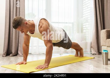 Muskulöser Mann, der Liegestütze während des Heimtrainings macht Stockfoto