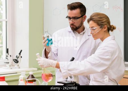 Kollegen von Wissenschaftlern arbeiten während der Forschung mit chemischen Reagenzien in einem Labor Stockfoto