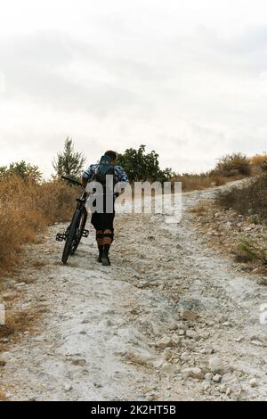 Professioneller Abfahrtsradarfahrer auf dem Bergweg Stockfoto