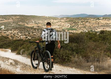 Professioneller Abfahrtsradarfahrer auf dem Bergweg Stockfoto