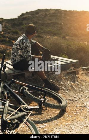 Radfahrer entspannen sich nach dem Downhillrennen auf dem Fahrrad in den Bergen Stockfoto