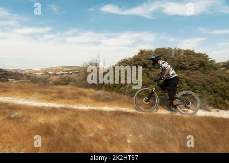 Professioneller Radfahrer bei der Abfahrt auf seinem Fahrrad in den Bergen Stockfoto