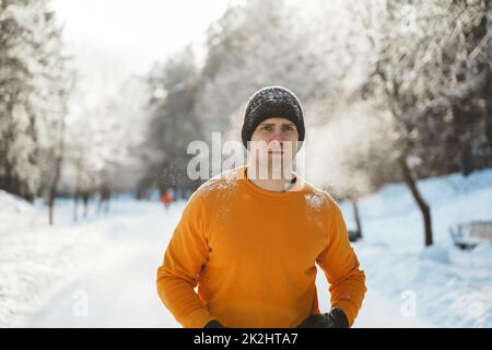 Junger Jogger während seines Trainings im Winterpark Stockfoto