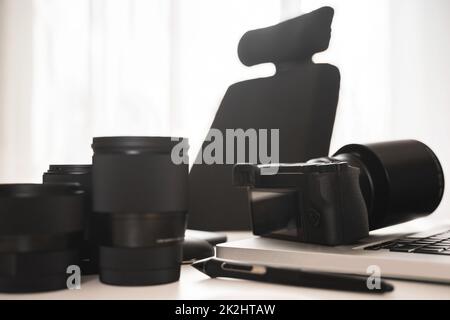 Arbeitsplatz mit moderner Ausrüstung für die Fotografie. Spiegellose Kamera und Objektive mit Festbrennweite. Stockfoto