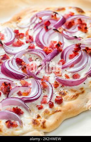 Pizza mit roten Zwiebeln, Speck und Rahm Stockfoto