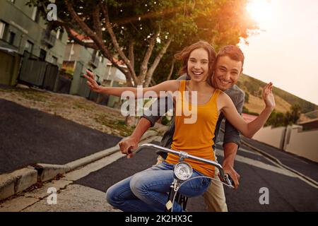 Liebe macht das Leben zu einer schönen Fahrt. Aufnahme eines glücklichen jungen Paares, das gemeinsam eine Fahrradtour macht. Stockfoto