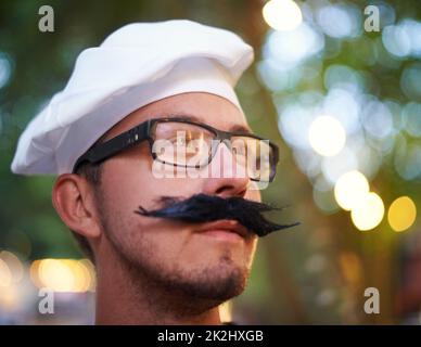 Französische Kleidung. Ein junger Mann, gekleidet in eine Baskenmütze und einen gefälschten Schnurrbart. Stockfoto