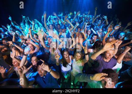 Genießen Sie jeden Song, den die Band spielt. Aufnahme einer großen Menschenmenge bei einem Musikkonzert. Stockfoto