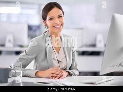 Sie hat es geschafft. Aufnahme einer attraktiven Geschäftsfrau, die in einem Büro an ihrem Schreibtisch sitzt. Stockfoto