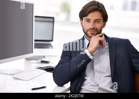 Selbstvertrauen. Ein attraktiver Geschäftsmann, der selbstbewusst auf die Kamera blickt. Stockfoto