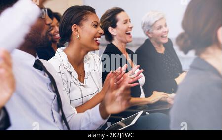 Applaudieren des besten Seminardozenten. Eine Aufnahme einer Gruppe von Geschäftsleuten, die tagsüber im Büro sitzen und klatschen. Stockfoto