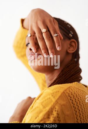 Sie hat so viel Haltung. Studioaufnahme einer Frau, die ihre Hand über ihr Gesicht hält, während sie vor einem weißen Hintergrund posiert. Stockfoto