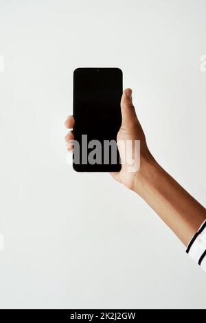 Lasst uns das viral machen. Ausgeschnittene Aufnahme einer Frau mit einem Smartphone vor einem weißen Studiohintergrund. Stockfoto