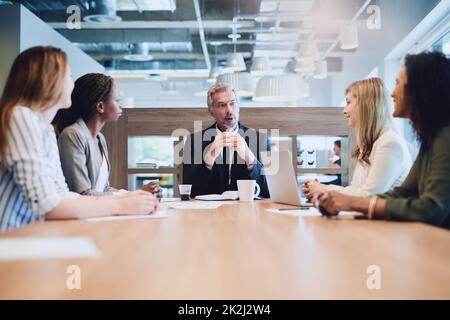 An der Spitze des Tisches und des Unternehmens. Eine Aufnahme eines hübschen, reifen Geschäftsmannes, der sich während einer Sitzung im Sitzungssaal an seine Kollegen wendet. Stockfoto