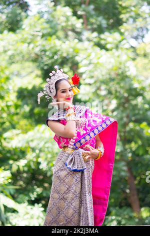 Asiatische Frau in einem typischen, traditionellen thailändischen Kleid. Traditioneller Tanz. Stockfoto