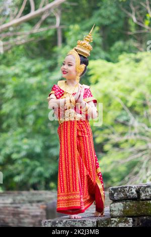 Asiatisches Mädchen in einem typischen, traditionellen Thai-Kleid. Traditioneller Tanz in Rot und Gold. Stockfoto