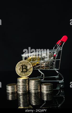 Bitcoin-Münzen im Warenkorb auf schwarzem Hintergrund Stockfoto