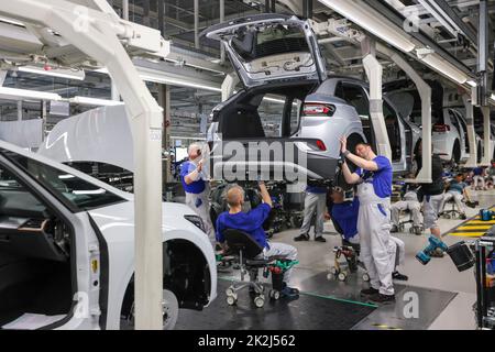 Zwickau, Deutschland. 26. April 2022. Im Volkswagen-Werk in Zwickau stellen Mitarbeiter eine ID.4 zusammen. Neben VW-Fahrzeugen kommen im Werk auch Fahrzeuge der Marken Audi und Seat vom Band. Die Fahrzeuge basieren auf dem Modular Electric Toolkit. Volkswagen hat den Standort, der rund 9.000 Mitarbeiter beschäftigt, zu einem Preis von 1,2 Milliarden ·in eine reine Elektrofahrzeugfabrik umgewandelt. Quelle: Jan Woitas/dpa/Alamy Live News Stockfoto