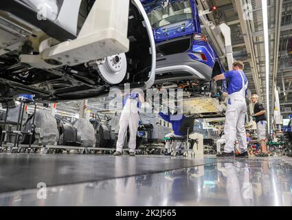 Zwickau, Deutschland. 26. April 2022. Im Volkswagen-Werk in Zwickau stellen Mitarbeiter eine ID.4 zusammen. Neben VW-Fahrzeugen kommen im Werk auch Fahrzeuge der Marken Audi und Seat vom Band. Die Fahrzeuge basieren auf dem Modular Electric Toolkit. Volkswagen hat den rund 9.000 Mitarbeiter beschäftigende Standort zu einem reinen Elektrofahrzeugwerk für 1,2 Milliarden Euro umgebaut. Quelle: Jan Woitas/dpa/Alamy Live News Stockfoto