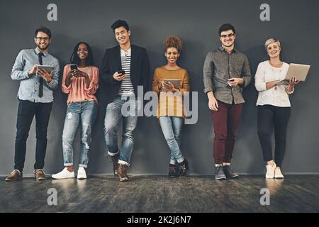 Soziale Netzwerke zu nutzen. Studio-Aufnahme einer vielfältigen Gruppe kreativer Mitarbeiter in sozialen Netzwerken. Stockfoto