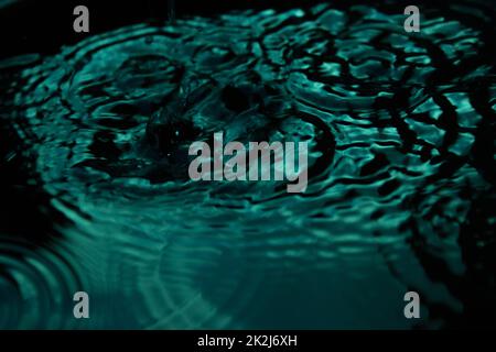 Wassertropfen, der über die Oberfläche springt Stockfoto