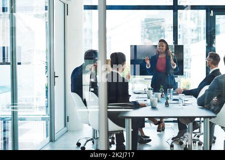 Man muss das große ganze sehen. In voller Länge eine attraktive junge Geschäftsfrau, die im Sitzungssaal eine Präsentation gehalten hat. Stockfoto