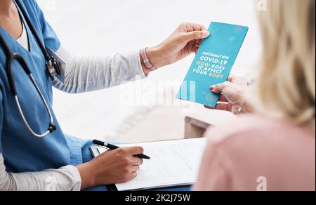 Dies wird Ihnen alles sagen, was Sie wissen müssen. Aufnahme einer Krankenschwester, die ihrem Patienten eine Covid-19 Informationsbroschüre gab. Stockfoto