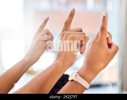 Erfolg erfordert Neugier. Zugeschnittene Aufnahme einer Gruppe von Personen, die während einer Präsentation die Hände heben. Stockfoto