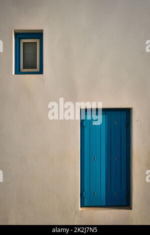 Griechische Architektur abstrakter Hintergrund - weiß getünchtes Haus mit blau bemalten Fensterläden